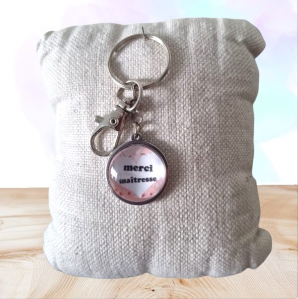 Offrez un porte-clés Merci Maîtresse en forme de cœur fleuri : cadeau artisanal et raffiné pour remercier une enseignante avec émotion et style.